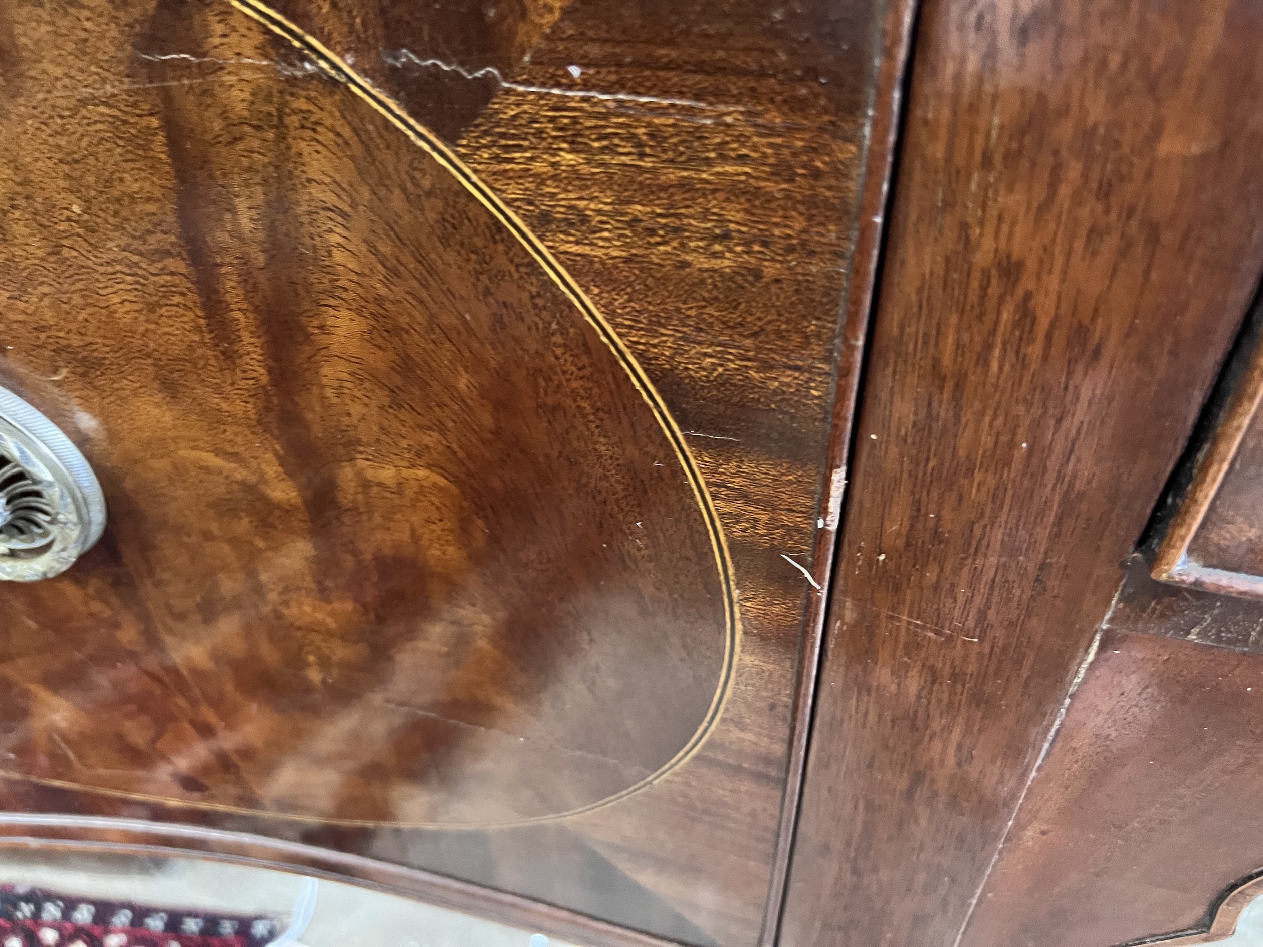 A George III style mahogany serpentine sideboard on square tapered legs, width 184cm, depth 63cm, height 93cm